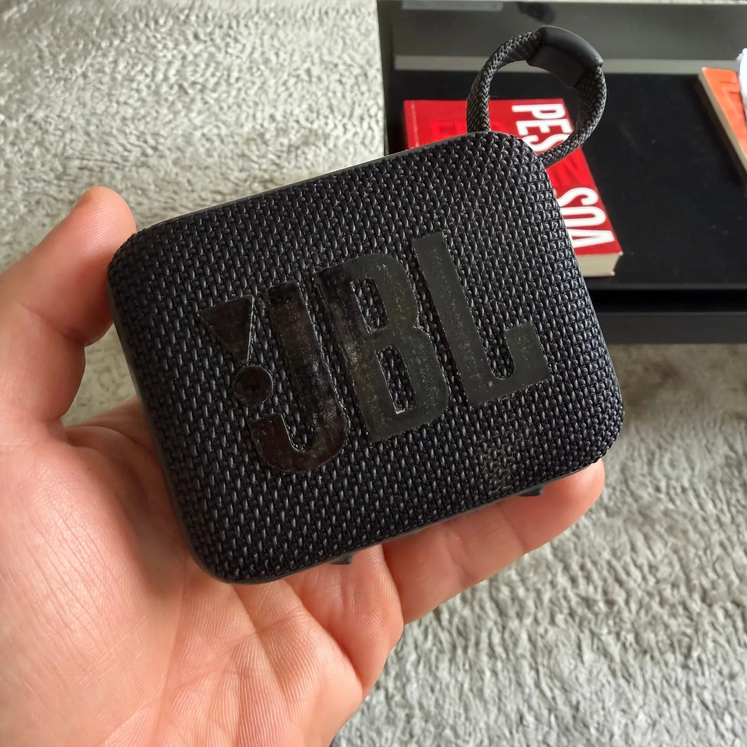 The little JBL Bluetooth speaker, held in one hand